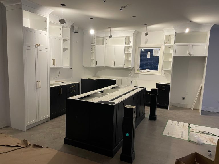 White shaker perimeter cabinets and black brass-hardware island during the hotel interior fit-out in Borjomi